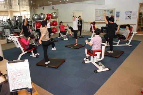 室内で運動指導スタッフの指導の元運動をしている町民たちの写真