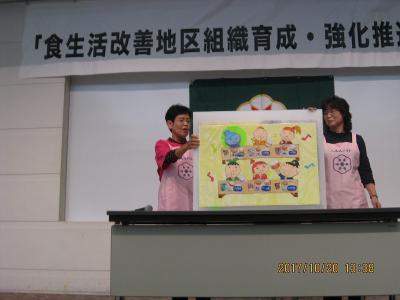 2人の女性が紙芝居を読んでいる写真