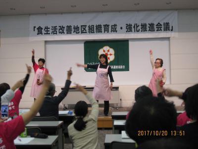 3人の女性が壇上で手を振っている写真