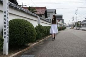 祐福寺の土塀の脇を散策する女性の写真
