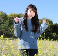 松井るなさんが花畑の中でポーズをとっている写真