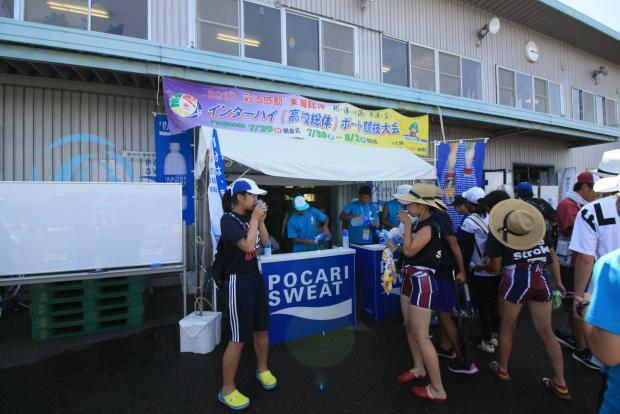 イベントテントでスポーツドリンクのサンプリング提供を行っている高校生スタッフらの写真