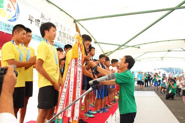 表彰台で優勝旗を授与される選手らの写真