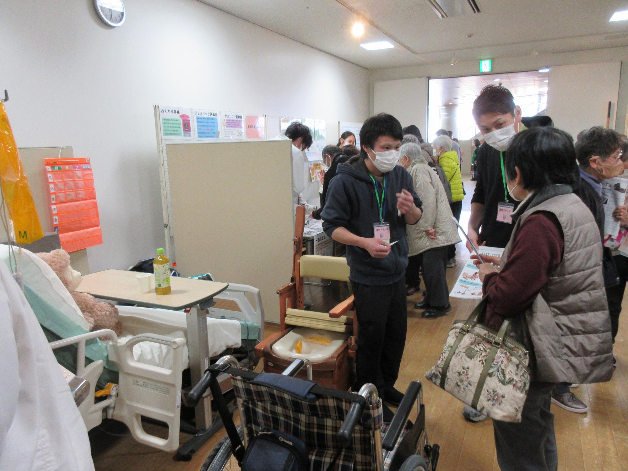 在宅医療・介護フェア（展示ブースで説明を受ける参加者）
