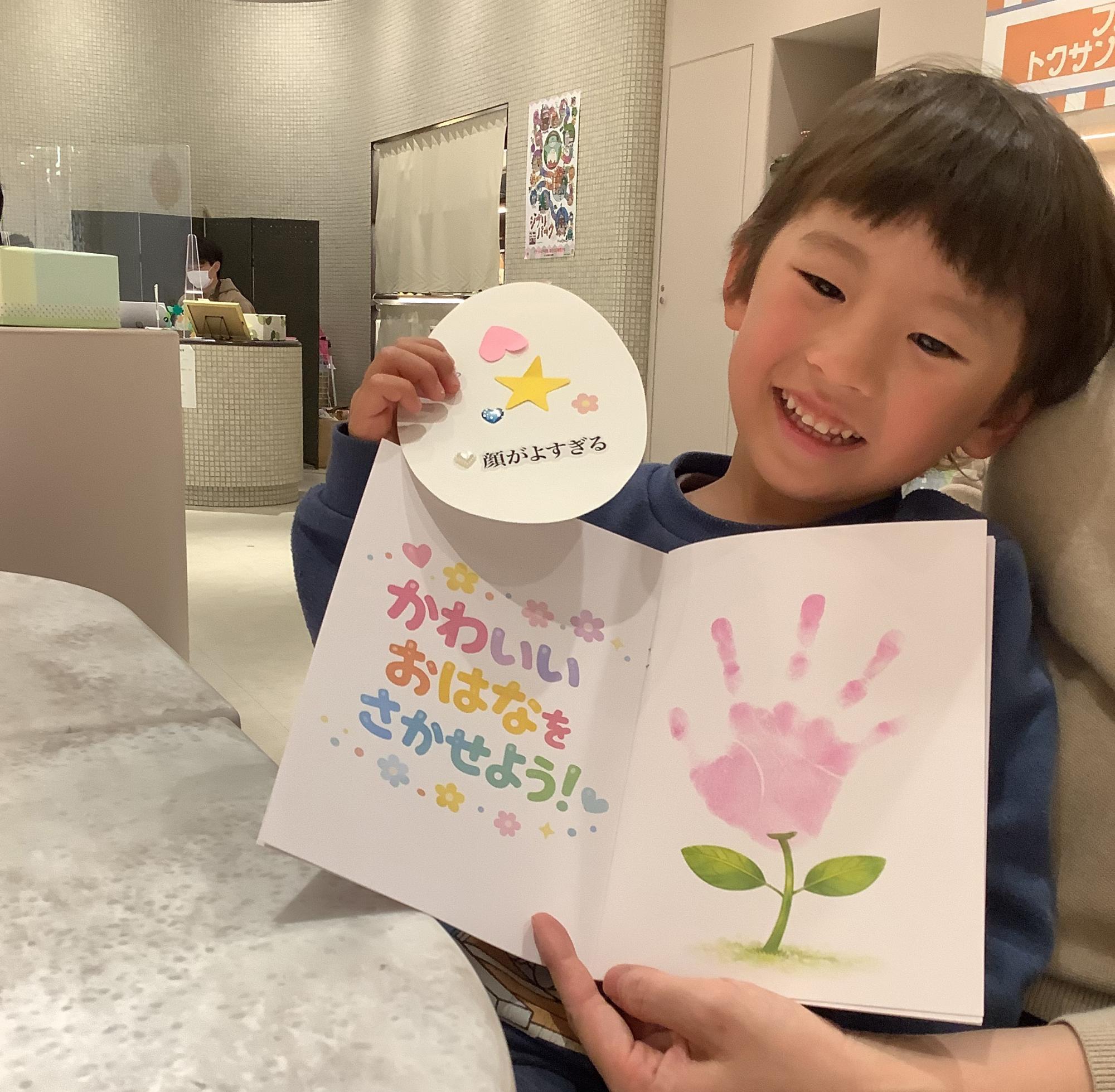 たまごカードと手形を披露する男の子