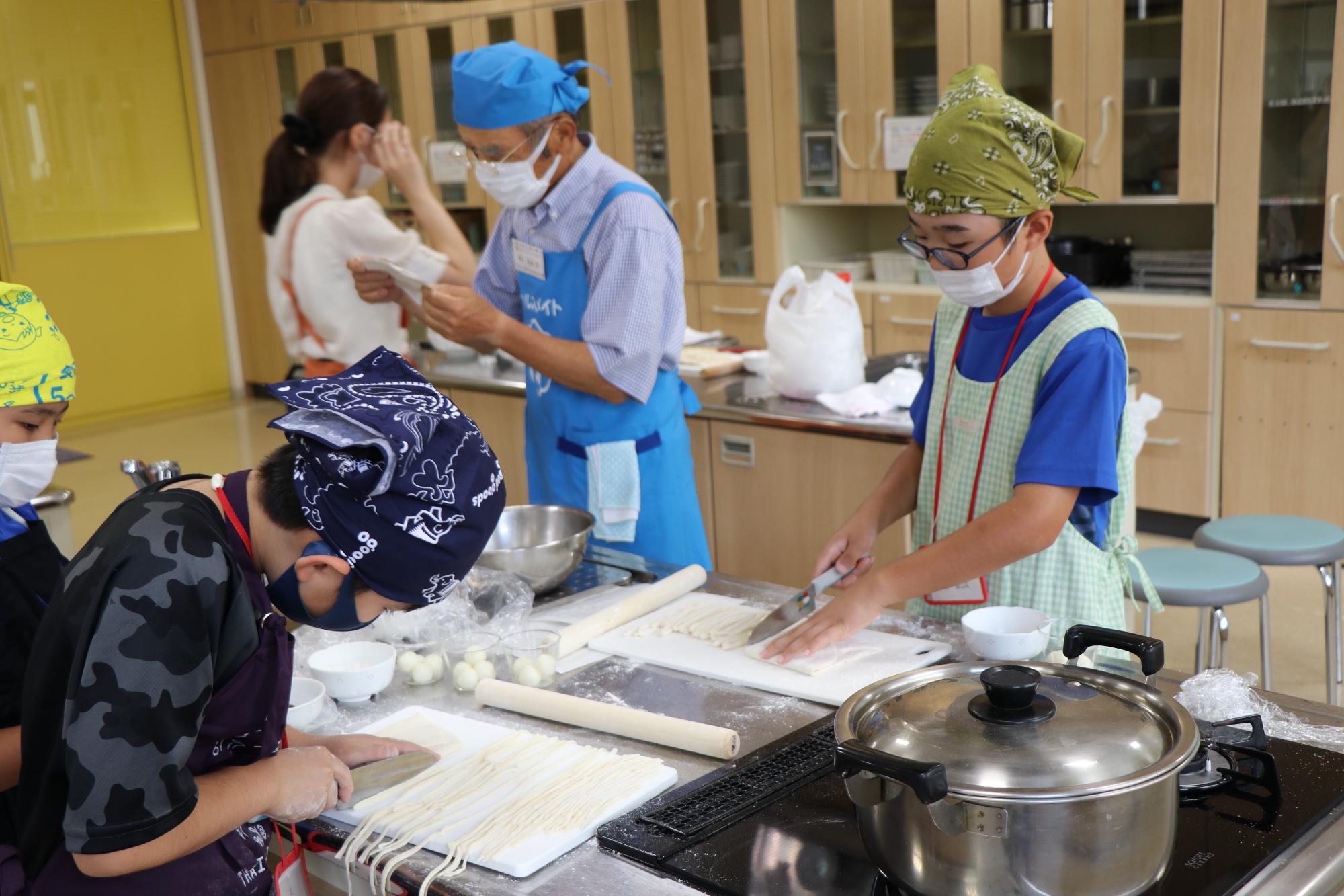 包丁でうどんの生地を切る