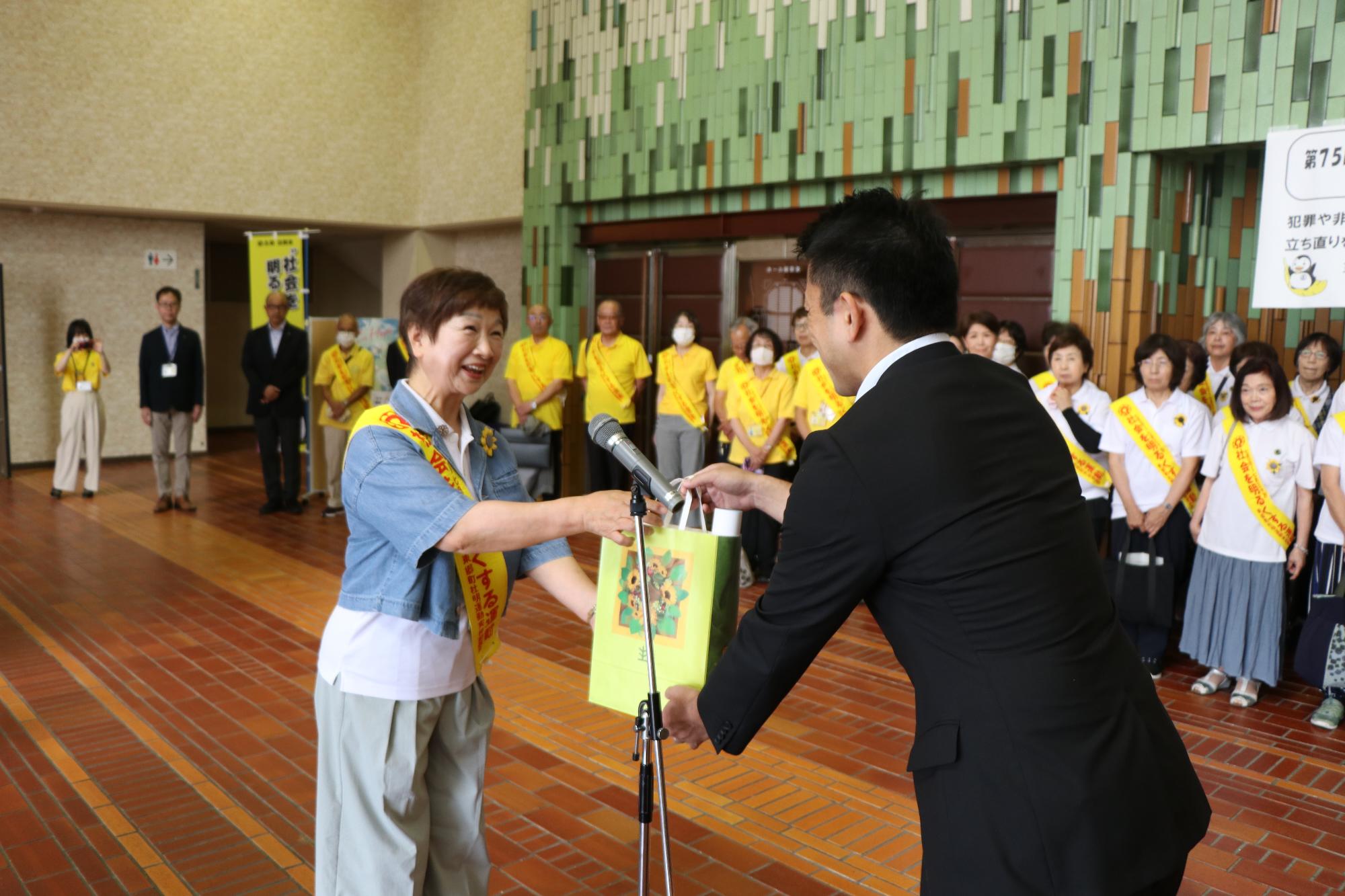 社会を明るくする運動出発式（啓発資材を受け渡す）