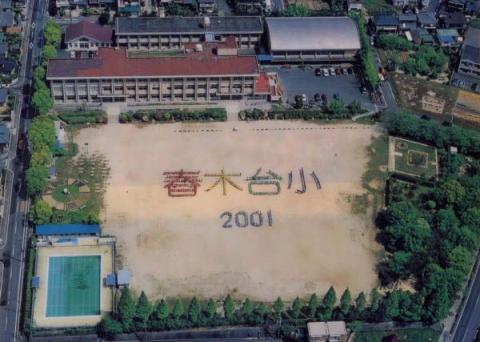校庭で「春木台小 2001」と色とりどりの人文字で表現したときの航空写真
