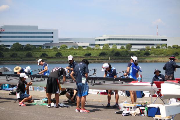 選手らがレースに向けボートの装備調整を行っている様子の写真